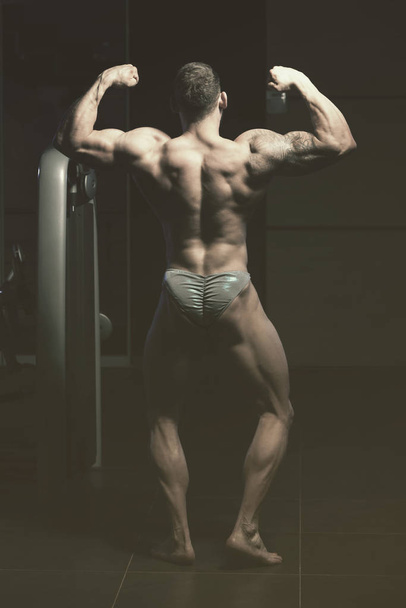 Muscular Men Is Hitting Rear Double Bicep Pose - Фото, зображення