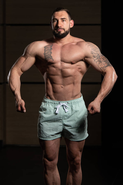 Serious Bodybuilder Standing In The Gym - 写真・画像