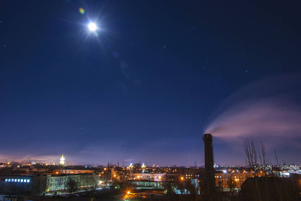 Éjszakai városi táj, központi kéménnyel. Füstszennyezés koncepció hosszú expozíciós hold táj - Fotó, kép