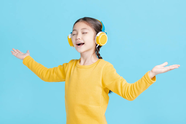 Menina feliz ouve música em fones de ouvido
 - Foto, Imagem