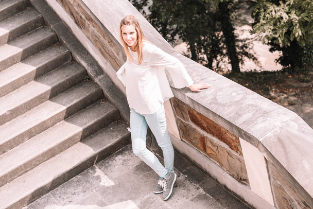 Блондинка позує на сходах в парку
 - Фото, зображення