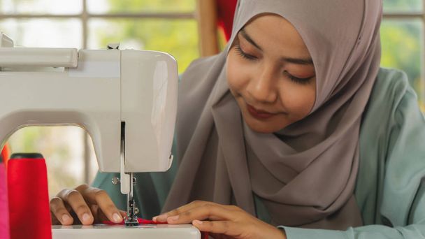 hands of muslim fashion designer using sewing machine making her - Valokuva, kuva