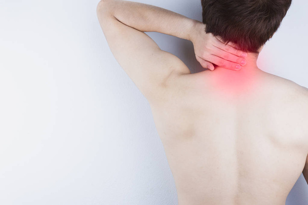 Homem close-up sofrendo de dor no pescoço e ombro com mancha vermelha
. - Foto, Imagem