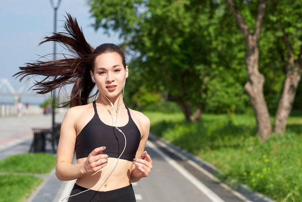 Running asian woman on running track. Morning jogging. The athlete training - Photo, Image