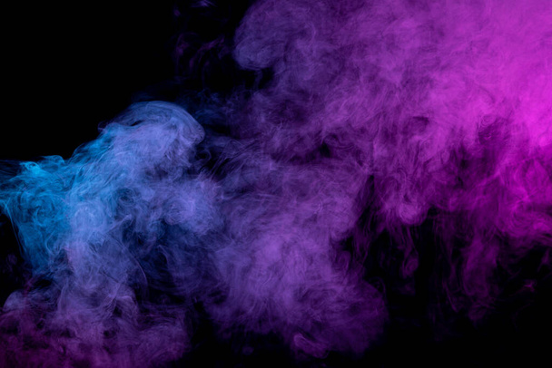 Siyah izole edilmiş arka planda pembe ve mavi bulut dumanı. Sis rengi, parlak pembe jel ve koyu arkaplan - Fotoğraf, Görsel