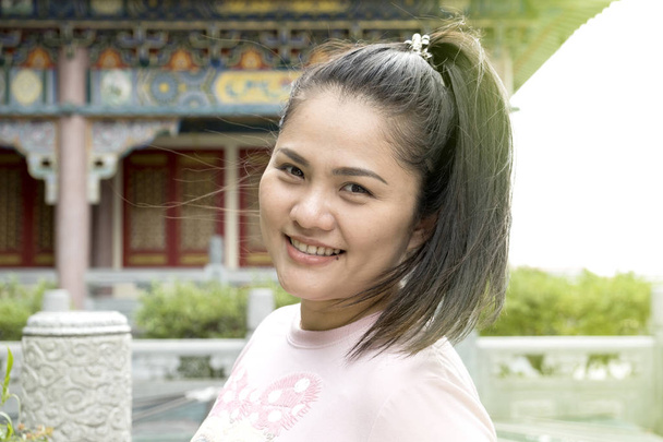 Portrét krásné asijské ženy usmívá šťastný na slunné léto ve večerních hodinách venku v čínském chrámu. - Fotografie, Obrázek