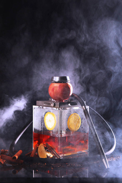 Hookah with a square flask based on tea. Tea and lemon in a transparent flask of a hookah. - Фото, изображение