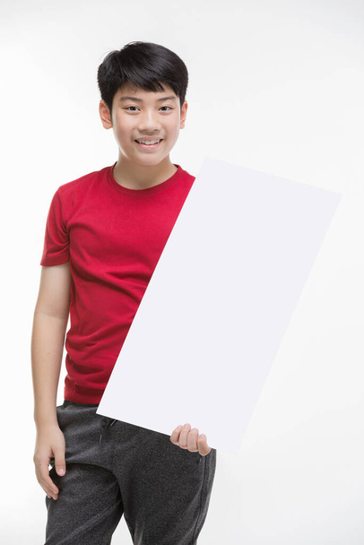 Chlapec drží prázdné znamení. Teen chlapec drží prázdný billboard. - Fotografie, Obrázek