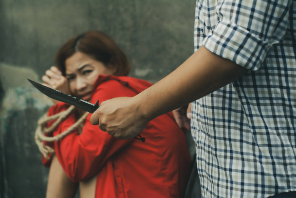 Злочинці використовують руки, тримаючи ножі для нападу і знущання над жінкою, життя
 - Фото, зображення
