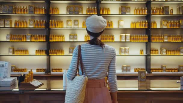 Nuori tyttö hyllyillä hajuveden kanssa ranskalaisessa kaupassa
 - Materiaali, video