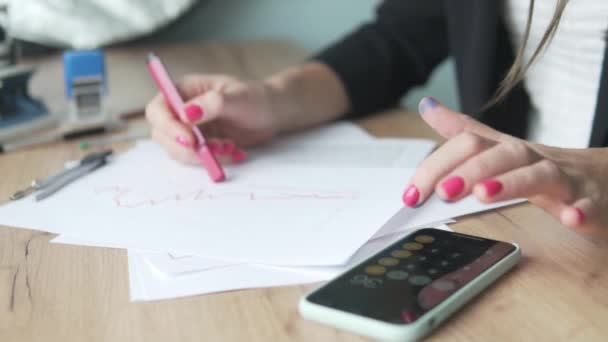 Žena v kanceláři pracuje s papíry a počítá data z kalkulačky. - Záběry, video