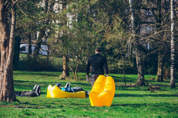 man walking with yellow inflatable mattress to place for reading book - Fotoğraf, Görsel