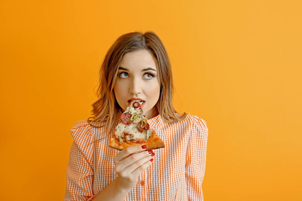 Portrét krásné mladé ženy jíst pizzu na barevném pozadí - Fotografie, Obrázek