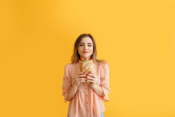 Portrét krásné mladé ženy s francouzským hot dog na barevném pozadí - Fotografie, Obrázek