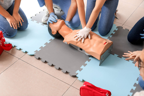 Инструкторы, демонстрирующие искусственное дыхание на манекене на курсах первой помощи
 - Фото, изображение