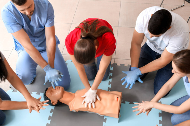 Instructors demonstrating CPR on mannequin at first aid training course - Fotoğraf, Görsel