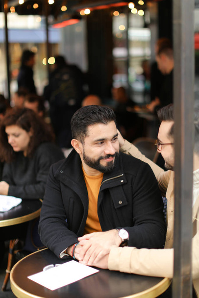 Dois jovens gays conversando no café e de mãos dadas
. - Foto, Imagem