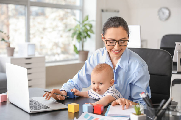 Mãe trabalhadora com seu bebê no escritório
 - Foto, Imagem