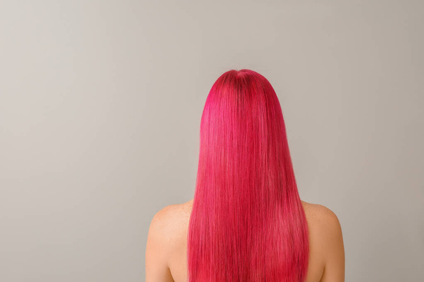 schöne junge Frau mit ungewöhnlicher Haarfarbe auf hellem Hintergrund - Foto, Bild