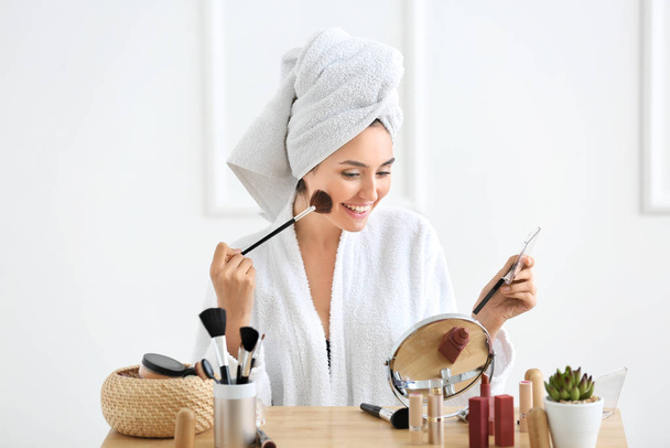 Mañana de hermosa mujer joven aplicando maquillaje en casa
 - Foto, Imagen