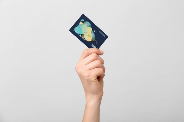 Female hand with credit card on light background - Foto, imagen