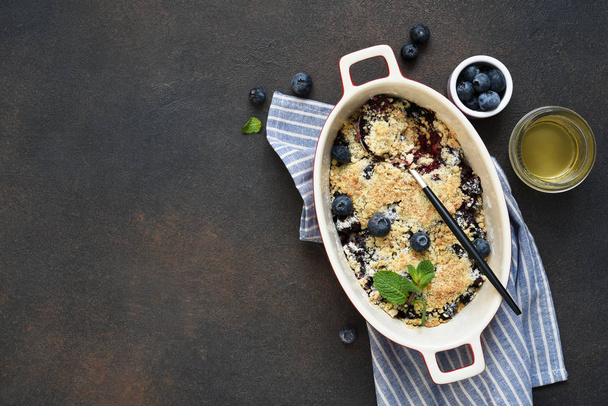 Crumble with berries, nuts and oatmeal on a concrete background. - Foto, afbeelding