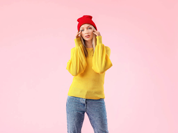 Νεαρή γυναίκα σε ζεστό πουλόβερ στο φόντο χρώμα - Φωτογραφία, εικόνα