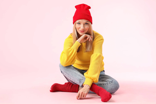 Молода жінка в теплому светрі на кольоровому фоні
 - Фото, зображення