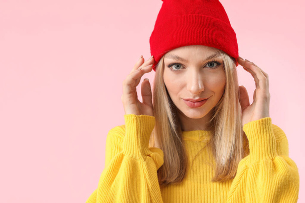 Young woman in warm sweater on color background - Foto, afbeelding