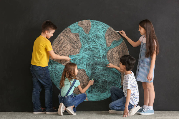 Pienet lapset piirtävät planeettaa pimeällä taustalla. Maan päivän juhla
 - Valokuva, kuva