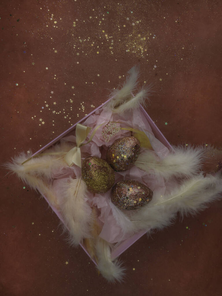 Paaseieren in een roze geschenkdoos met veren - Foto, afbeelding