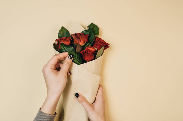 female hands holding beautiful bouquet with red roses, elegant floral decoration - Fotó, kép
