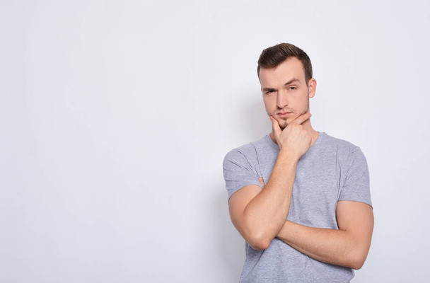Thoughtful, bored young Caucasian guy on a white background. - Foto, Imagen
