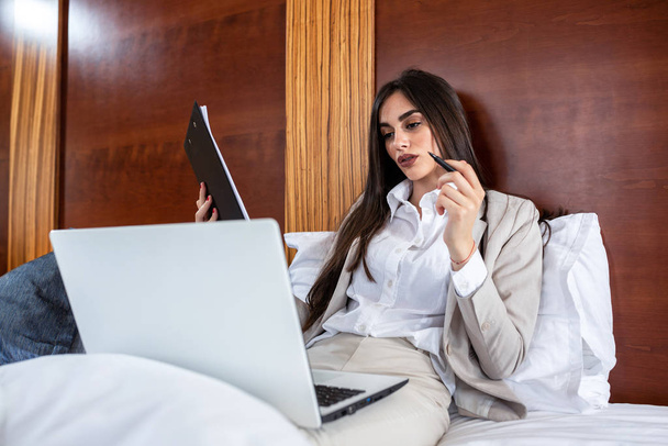 Elegant business woman sitting on the bed  - Фото, изображение