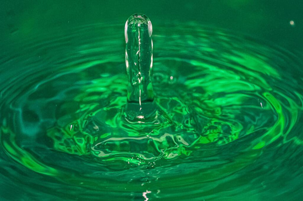 A closeup shot of a water splash and ripples on green water - Foto, Bild