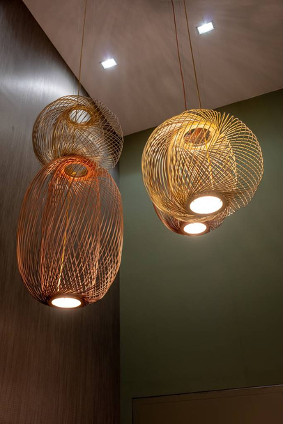 A vertical shot of a couple of decorative lamps hanging from the ceiling - Foto, Imagen