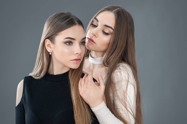 two beautiful sisters dressed in white and black, concept of lifestyle of people, girlfriends - Zdjęcie, obraz