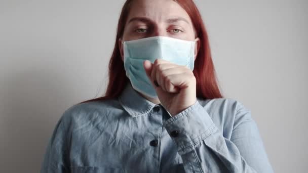 Orvosi maszkos lány köhög. Egy beteg köhög. Hányinger, megfázás és vírusfogalom. - Felvétel, videó