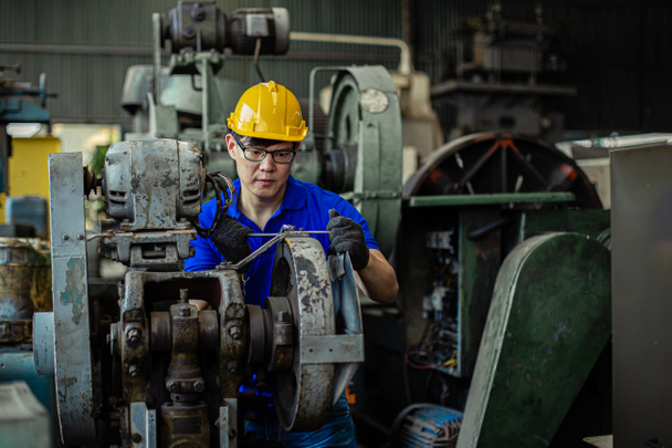 Homme Industrie portant casque de sécurité machine de réparation de travail en usine
. - Photo, image
