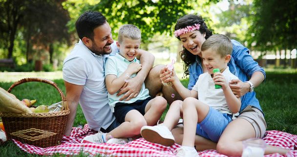 Familia feliz disfrutando de un picnic con niños en la naturaleza
 - Foto, imagen