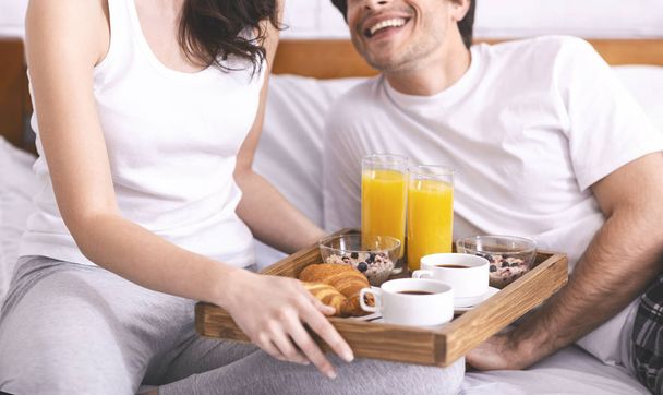 Jeune couple marié appréciant le petit déjeuner au lit
 - Photo, image