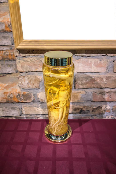 Bottiglia di vetro vintage con tintura di guarigione radice di ginseng intero
 - Foto, immagini