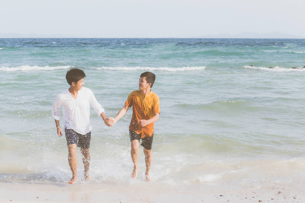 Homossexual retrato jovem asiático casal correndo com alegre juntos na praia no verão, ásia gay indo turismo para lazer e relaxar com a felicidade em férias no mar, LGBT conceito legal
. - Foto, Imagem