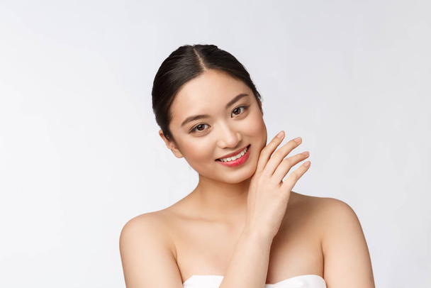 Güzel Asyalı kadın makyaj malzemesi, el, yanak ve gülümseme, güzel yüz, beyaz arka planda izole edilmiş sağlıkla mükemmel.. - Fotoğraf, Görsel