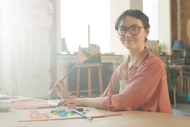 Женщина рисует за столом
 - Фото, изображение
