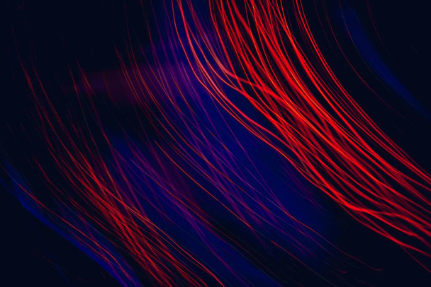 A graphic illustration of neon red and blue laser lights with a black background - Foto, imagen