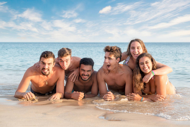 Група щасливих молодих людей на пляжі
 - Фото, зображення