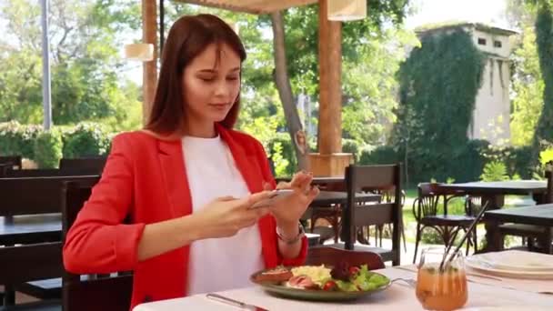 girl in a restaurant takes pictures of food - Footage, Video