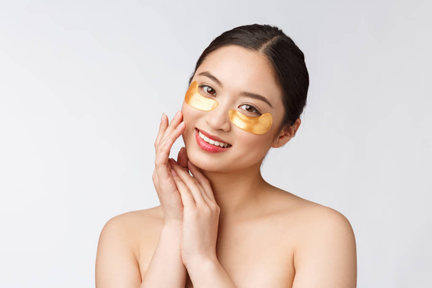 asiático belleza adolescente mujer cuidado su piel con oro ojo máscaras parches bajo ojos
 - Foto, Imagen