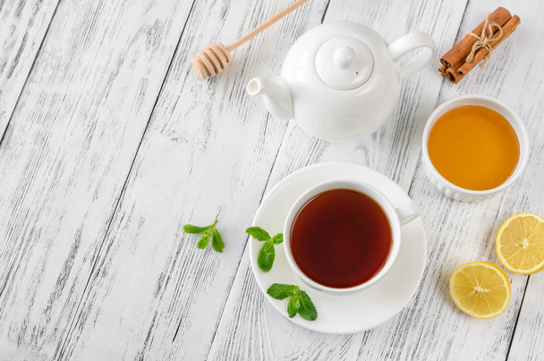Cup of black tea with honey, lemon and spices on wooden background: top view - Foto, Imagem